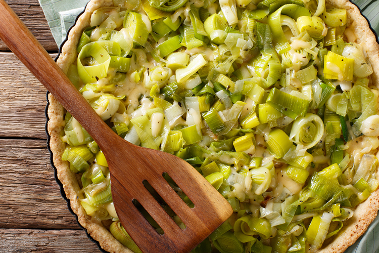 freshly baked savory leek pie with cheese close-up on the table. Horizontal view from above